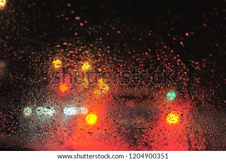 red and yellow lights behind the glass in the rain