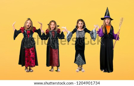 Set of Little girl dressed as a vampire for halloween holidays with surprise and shocked facial expression on orange background