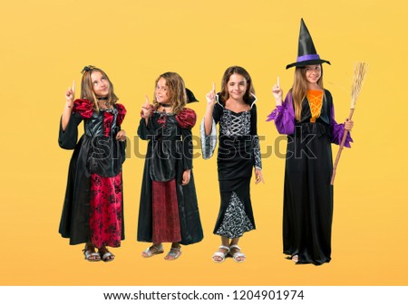 Set of Little girl dressed as a vampire for halloween holidays counting number one sign on orange background