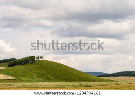 Green hills with clouds in the horizon. Blue sky and white clouds. Are not far from lake Shira, Russia, Khakasia Hakasia Royalty-Free Stock Photo #1204904161