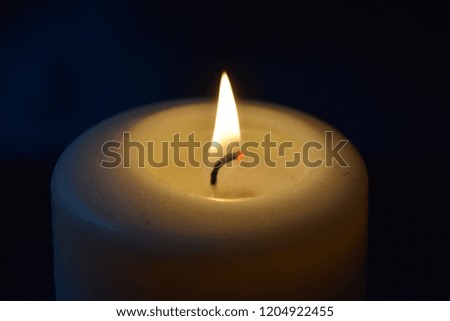 White candle light flame dark background