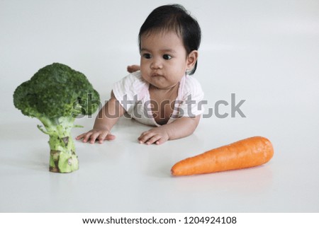 reaction a seven months old baby girl with broccoli and carrot. 