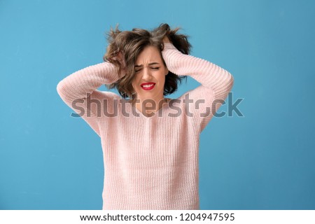 Portrait of beautiful stressed woman on color background Royalty-Free Stock Photo #1204947595