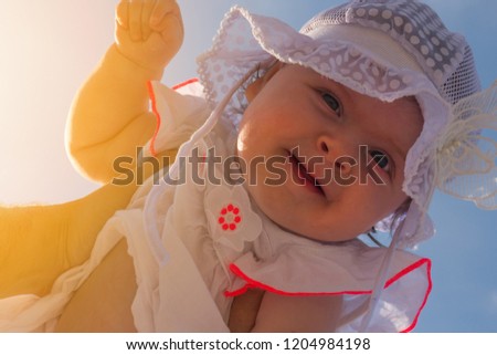 Dad holds a child over his head. Half a year old baby. Walk down the street. Summer day