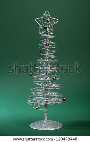 Silver Christmas tree with ornaments. Green Background