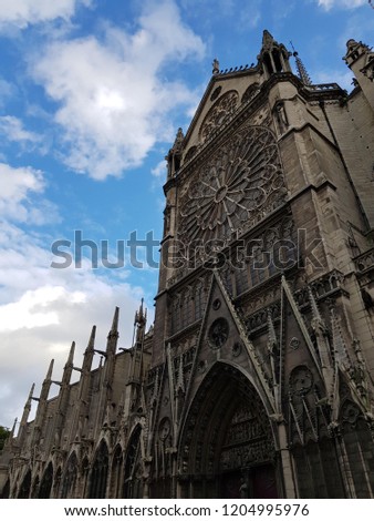 Detail of the Notre Dame de Paris on the background of beautiful  
cloudy and blue sky. Paris, France