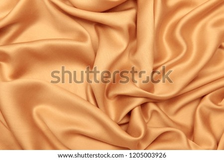 Background and texture. The concept of hobby and production. Image of the texture of the fabric for clothing. Beige silk. Abstraction. Cropped shot, isolated, close-up, blurred, horizontal
