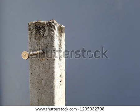 bolt stainless steel long nail in hole concrete pol square dirty column gray background