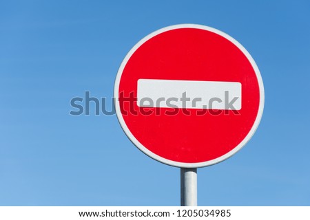 Round road stop sign, on a pole against the sky