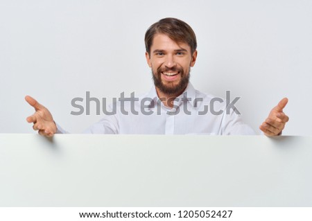 happy man stands behind white mockup                         