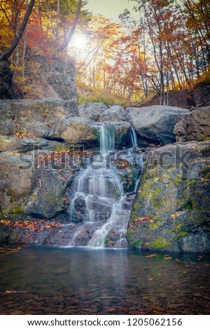 Small waterfalls cascade in autumn season colors in the forest near Vladivostok, Russia
