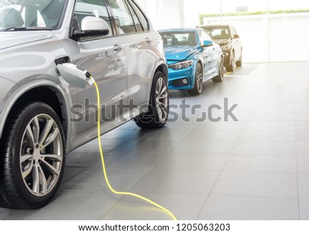 Close up of the Hybrid car electric charger station with power supply plugged into an electric car being charged.	 Royalty-Free Stock Photo #1205063203