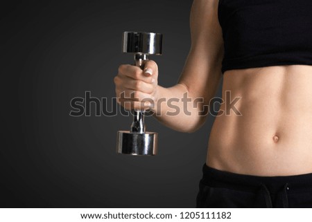 Beautiful fitness woman with lifting dumbbells .