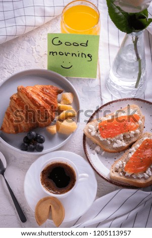 Continental breakfast captured from above (top view, flat lay). Coffee, orange juice, croissant, sandwich and flowers. sticker note wishing