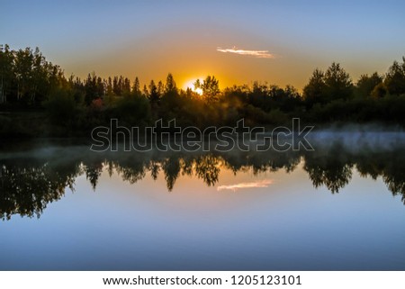 Sunrise by the Lake with the yellow light reflecting in the water
