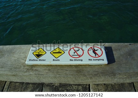 Shallow water, Boats, No Diving, and No Jumping sign at beach