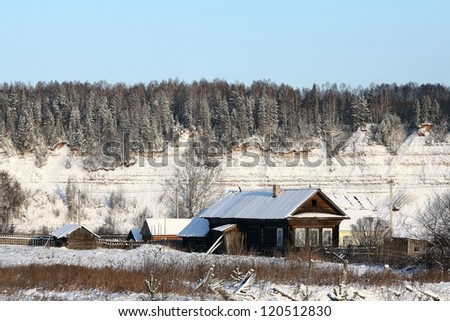 Village in winter, the snow-covered countryside, forest and wood houses