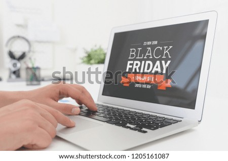 Man using laptop with Black Friday promotion sale on screen