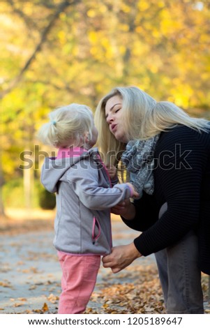 Mother with little daughter playing in the park.