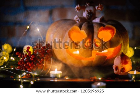 Halloween pumpkin in smoke on black background and brick wall, scary doll