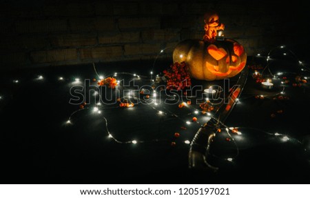 Halloween pumpkin in smoke on black background and brick wall, scary doll