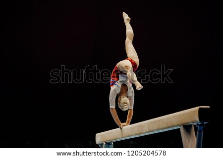 balance beam handstand female gymnast on black background Royalty-Free Stock Photo #1205204578