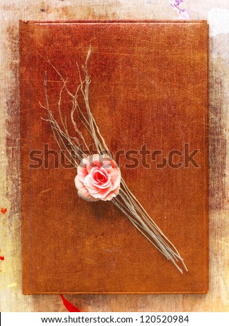 Old notebook background with flower/ vintage notebook on brown timber background.