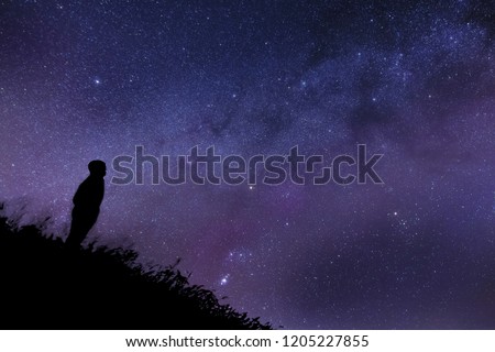 Silhouette of a lonely man watching the stars and part of the MIlky Way. 