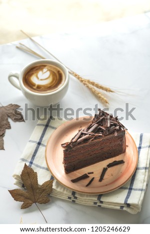 Chocolate Cake and Coffee.Chocolate cake on pink plate.Cake on white marble background.