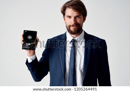man in a suit holding a hard disk                             