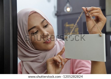 malay woman holding blank wooden sign-small business concept