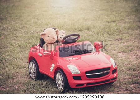 Two teddy bears in big  toy car at park