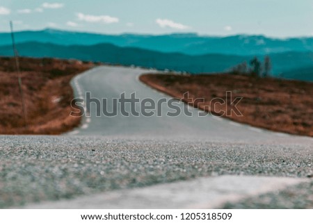 Picture of a beautiful road in Norway. Beautiful Norwegian scenery with Mountains and blue skies the background. 