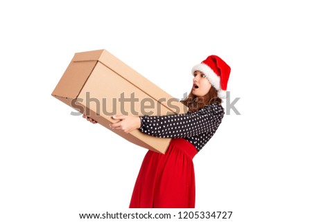 Portrait of excited surprised girl in dress holding big and heavy gift box. isolated on white background. holidays concept.