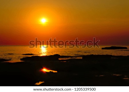 Colorful sunset over the North sea with rocks in the water along the opal coast in Nord Pas de Calais region, France