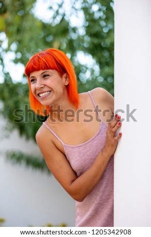 Funny young woman with pink t-shirt and orange hair
