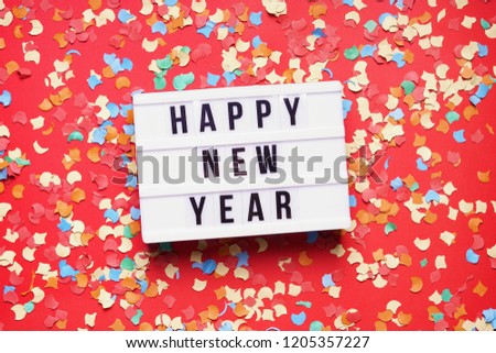 happy new year party celebration flat lay with confetti on red background