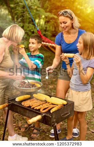 Young parents with children enjoy  barbecue outside