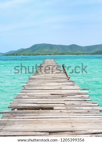 This picture is a wooden bridge extending into the sea. It to see that long and think do not walk to the end. 