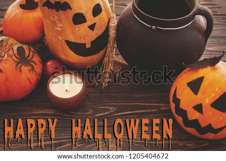 Happy Halloween text, bloody sign on pumpkins, jack-o-lantern, witch cauldron,bats, spider, candle,ghost, autumn leaves on dark background. Space for text. Halloween decorations. Season's greeting