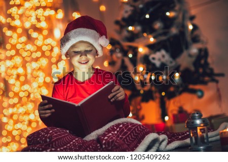 Surprised child opening magic Christmas book. Xmas holiday concept