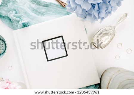 Family wedding photo album, pastel colorful hydrangea flower bouquet, turquoise blanket, decoration on white background. Flat lay, top view vintage decorated concept.