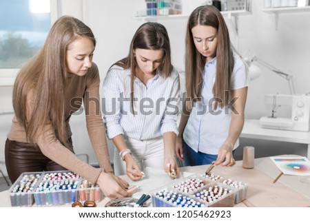 young girls pick up a coil of thread in color to the fabric