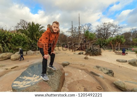 Blond boy playing on playground with pirate ship, in Royal Borough of Kensington and Chelsea, London - 2018. Diana, Princess of Wales in Kensington Gardens, in Royal Borough of Kensington and Chelsea