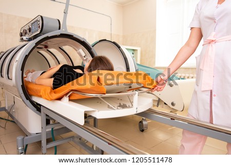 doctor in a white coat opens and pulls out a girl in a black T-shirt from the altitude chamber Royalty-Free Stock Photo #1205511478