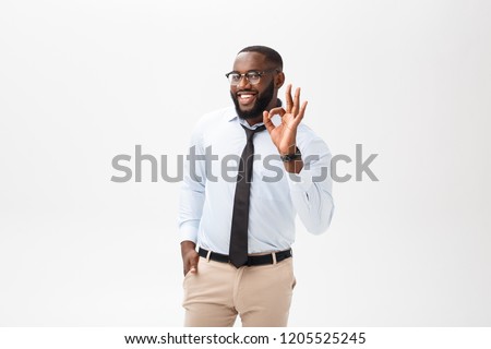 Young black businessman having happy look, smiling, gesturing, showing OK sign. African male showing OK-gesture with his fingers. Body language concept.