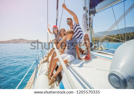Happy family with adorable daughter and son resting on a big yacht Royalty-Free Stock Photo #1205570335