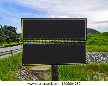 Signboard of empty black mock up, mockup signage with shadow in dark frame with nature.Space for text input. sign on the nature