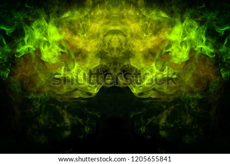 Mocap for cool t-shirts. Cloud of yellow and green smoke in the form of a skull, monster, dragon on a black isolated background. Background from the smoke of vape