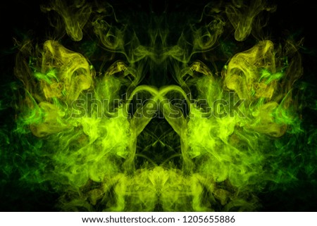 Mocap for cool t-shirts. Dense multicolored smoke of   yellow and green  colors in the form of a skull, monster, dragon  on a black isolated background. 